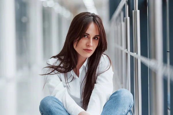 Brunette White Shirt Sits Indoors Modern Airport Hallway Daytime — Stock fotografie