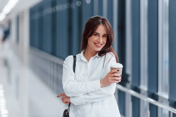 Brunette White Shirt Indoors Modern Airport Hallway Daytime Holding Cup — Fotografia de Stock