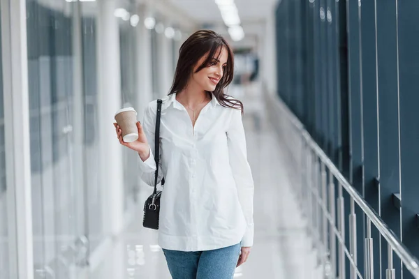 Brunette White Shirt Indoors Modern Airport Hallway Daytime Holding Cup — Fotografia de Stock