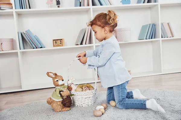 Paskalya tatilini evde kutlarken yumurta dolu sepeti tutan tatlı küçük kız..