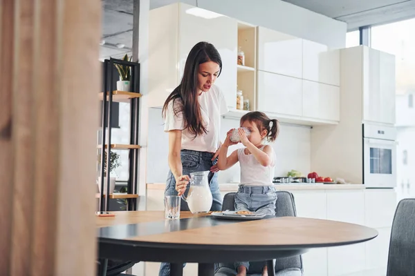 Madre Vertiendo Leche Fresca Vaso Para Hija Pequeña Cocina —  Fotos de Stock