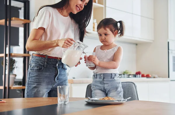 Mother Pouring Fresh Milk Glass Her Little Daughter Kitchen — Stock Photo, Image