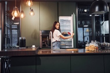 Taze yemek hazırlıyorum. Genç ve güzel esmer, gündüzleri evde, mutfakta günlük giysiler içinde..