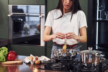 Gündüz vakti mutfakta sağlıklı yiyecekler hazırlayan günlük kıyafetlerle güzel bir esmer kız..