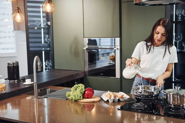 Sebze ve sağlıklı ürünler kullanarak yemek hazırlamak. Genç ve güzel esmer, gündüzleri evde, mutfakta günlük giysiler içinde..