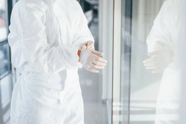穿着实验室外套 防护眼镜和面具站在室内戴手套的女医生科学家 — 图库照片