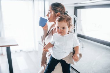 Female blogger mother with her kid together indoors at home at weekend.