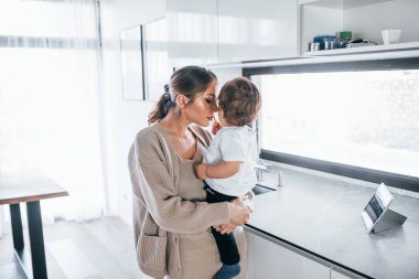 Female blogger mother with her kid together indoors at home at weekend.
