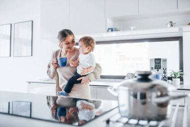 Female blogger mother with her kid together indoors at home at weekend.