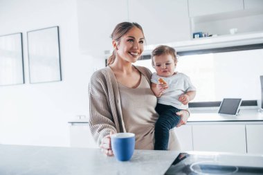 Female blogger mother with her kid together indoors at home at weekend.
