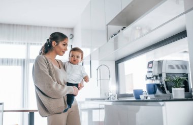 Female blogger mother with her kid together indoors at home at weekend.