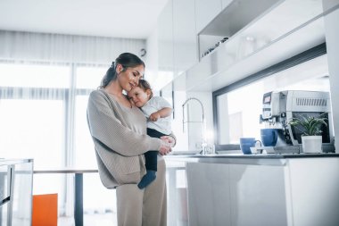 Female blogger mother with her kid together indoors at home at weekend.