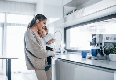 Female blogger mother with her kid together indoors at home at weekend.