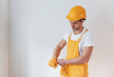 Sarı üniformalı tamirci içeride çalışmaya hazırlanıyor. Ev yenileme konsepti.