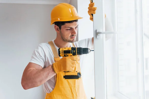 Handyman Uniforme Amarelo Instala Nova Janela Usando Chave Fenda Automática — Fotografia de Stock