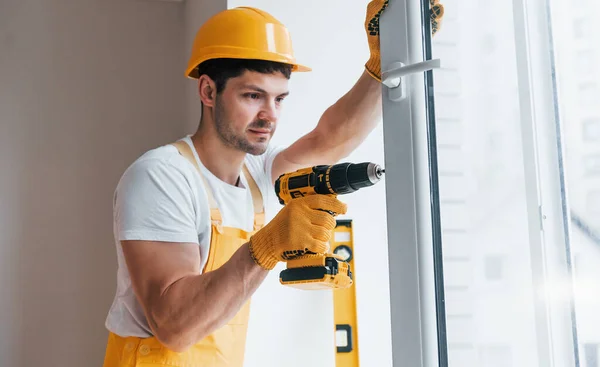 Handyman Uniforme Amarillo Instala Una Nueva Ventana Mediante Uso Destornillador — Foto de Stock