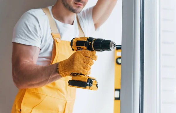 Handyman Yellow Uniform Installs New Window Using Automatic Screwdriver House — Zdjęcie stockowe