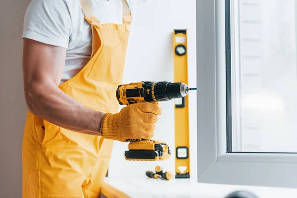 Handyman Yellow Uniform Installs New Window Using Automatic Screwdriver House — Zdjęcie stockowe