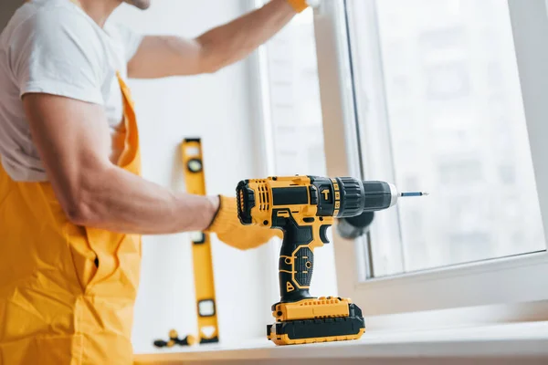 Handyman Yellow Uniform Installs New Window Using Automatic Screwdriver House — Zdjęcie stockowe