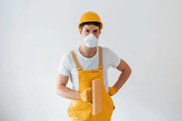 Handyman Uniforme Amarillo Máscara Protectora Pie Contra Pared Blanca Concepto —  Fotos de Stock