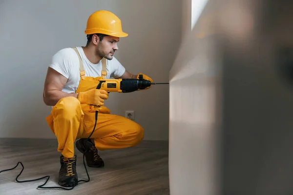 Złota Rączka Żółtym Mundurze Pracuje Wiertłem Pomieszczeniu Koncepcja Renowacji Domu — Zdjęcie stockowe