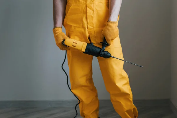 Handwerker Gelber Uniform Mit Bohrmaschine Steht Drinnen Konzept Zur Haussanierung — Stockfoto
