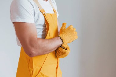 Sarı üniformalı tamirci içeride çalışmaya hazırlanıyor. Ev yenileme konsepti.