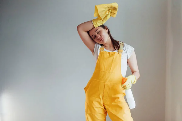 Tired Housewife Yellow Uniform Standing Cleaning Spray Windows Indoors House — Stock Photo, Image