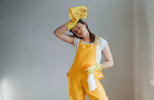 Tired Housewife Yellow Uniform Standing Cleaning Spray Windows Indoors House — Stok fotoğraf