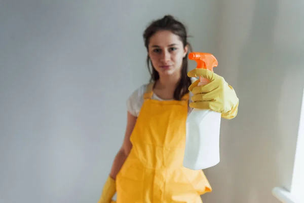 Gospodyni Domowa Żółtym Mundurze Stojąca Sprayem Czyszczenia Okien Pomieszczeniach Koncepcja — Zdjęcie stockowe