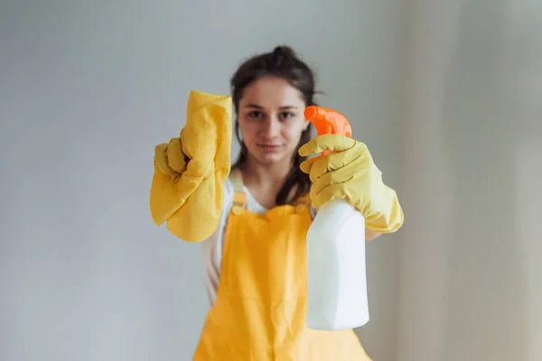 Gospodyni Domowa Żółtym Mundurze Stojąca Sprayem Czyszczenia Okien Pomieszczeniach Koncepcja — Zdjęcie stockowe