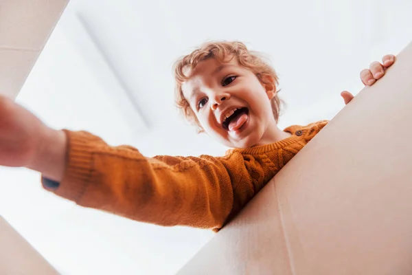Kıvırcık Saçlı Karton Kutuyla Eğlenen Küçük Çocuğun Manzarası — Stok fotoğraf