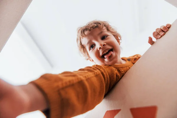 Kıvırcık Saçlı Karton Kutuyla Eğlenen Küçük Çocuğun Manzarası — Stok fotoğraf