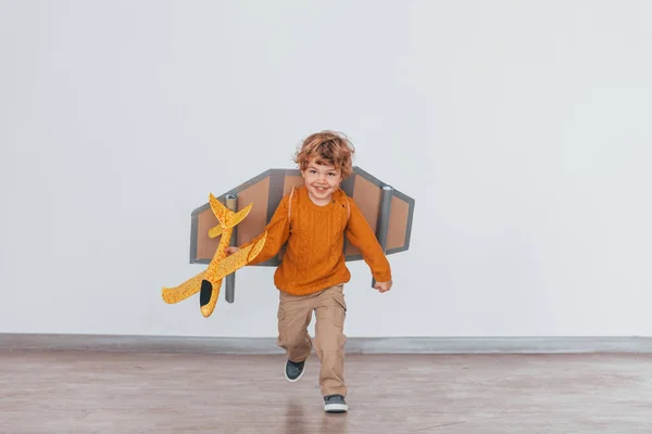 Little Boy Retro Pilot Uniform Running Toy Plane Indoors — Stok fotoğraf