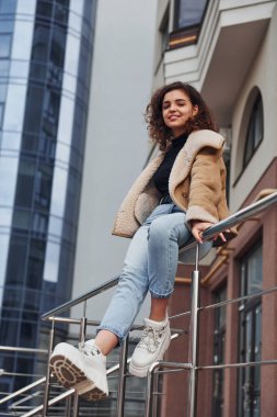 Genç kız şehir dışında iş binasının yakınında yürüyüşe çıktı..