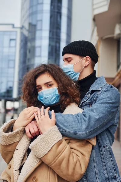 Couple Protective Masks Embracing Each Other City Business Building Quarantine — Zdjęcie stockowe