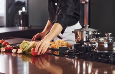 Sebze. Üniformalı profesyonel aşçı mutfakta çalışıyor..