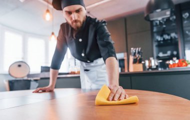 Mutfaktaki üniformalı temizlik masasında profesyonel bir aşçı..