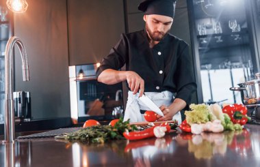 İşlem hazırlanıyor. Üniformalı profesyonel aşçı mutfakta çalışıyor..