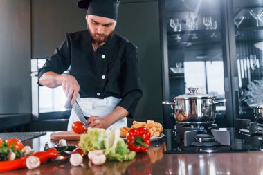 İşlem hazırlanıyor. Üniformalı profesyonel aşçı mutfakta çalışıyor..