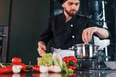 İşlem hazırlanıyor. Üniformalı profesyonel aşçı mutfakta çalışıyor..