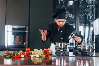 İşlem hazırlanıyor. Üniformalı profesyonel aşçı mutfakta çalışıyor..