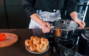 Mutfakta çalışan, üniformalı, profesyonel aşçıya yakından bakın..