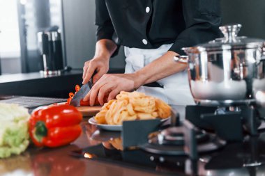 Mutfakta çalışan, üniformalı, profesyonel aşçıya yakından bakın..