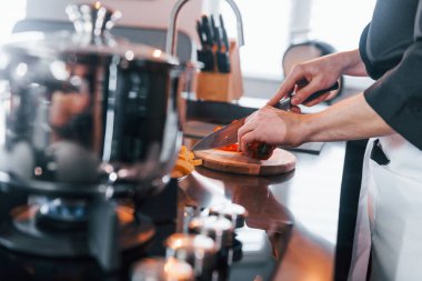 Mutfakta çalışan, üniformalı, profesyonel aşçıya yakından bakın..