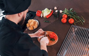 Mutfakta çalışan, üniformalı, profesyonel aşçıya yakından bakın..