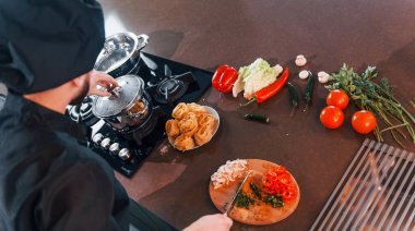 Mutfakta çalışan, üniformalı, profesyonel aşçıya yakından bakın..