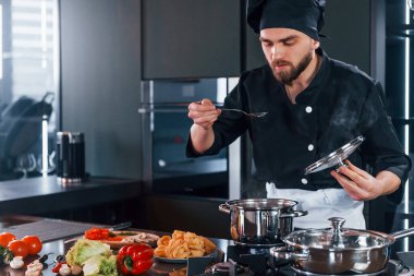 Üniformalı profesyonel aşçı mutfakta çalışıyor..