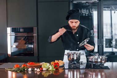 Üniformalı profesyonel aşçı mutfakta çalışıyor..