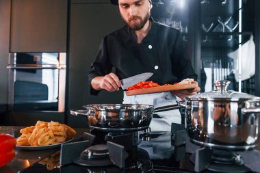 Üniformalı profesyonel aşçı mutfakta çalışıyor..